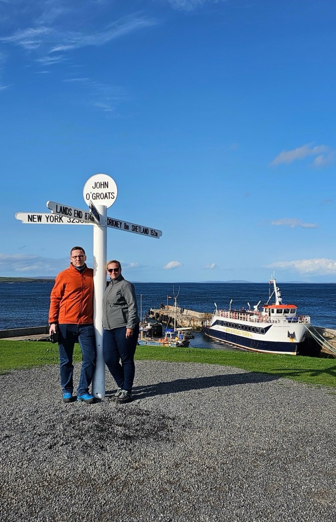 Para turystów przy znaku John O’Groats w Szkocji
