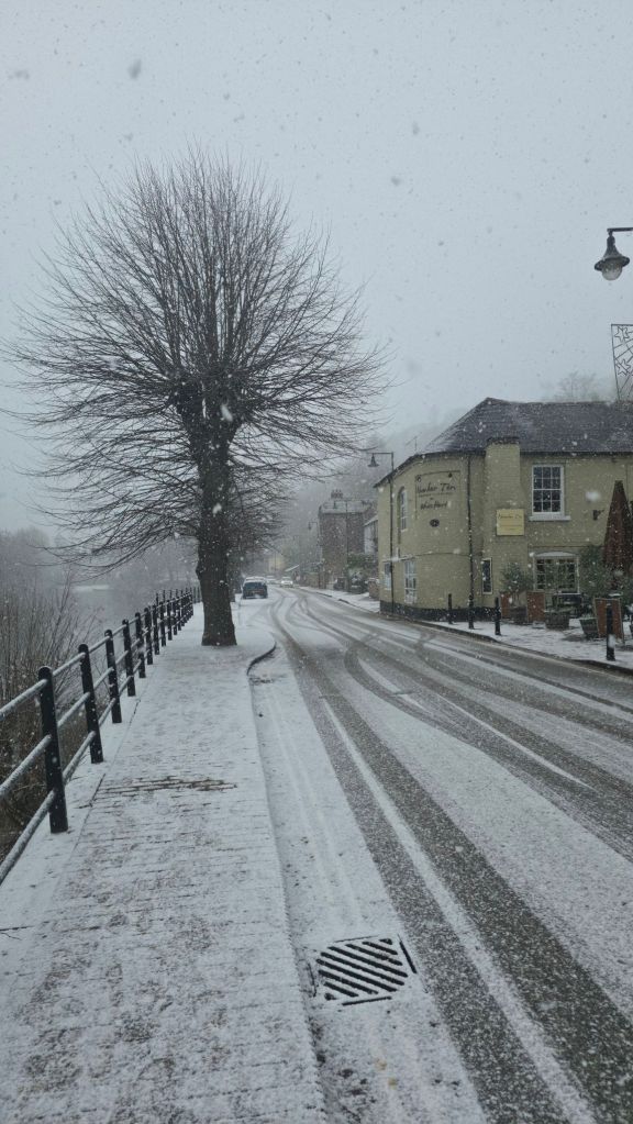 Bulwar miejski wzdłuż rzeki Severn w trakcie opadów śniegu w Ironbridge 