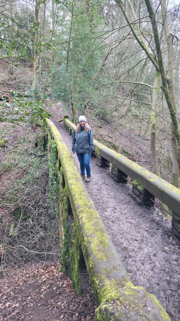 Kobieta stojąca na kamiennym, starym moście.