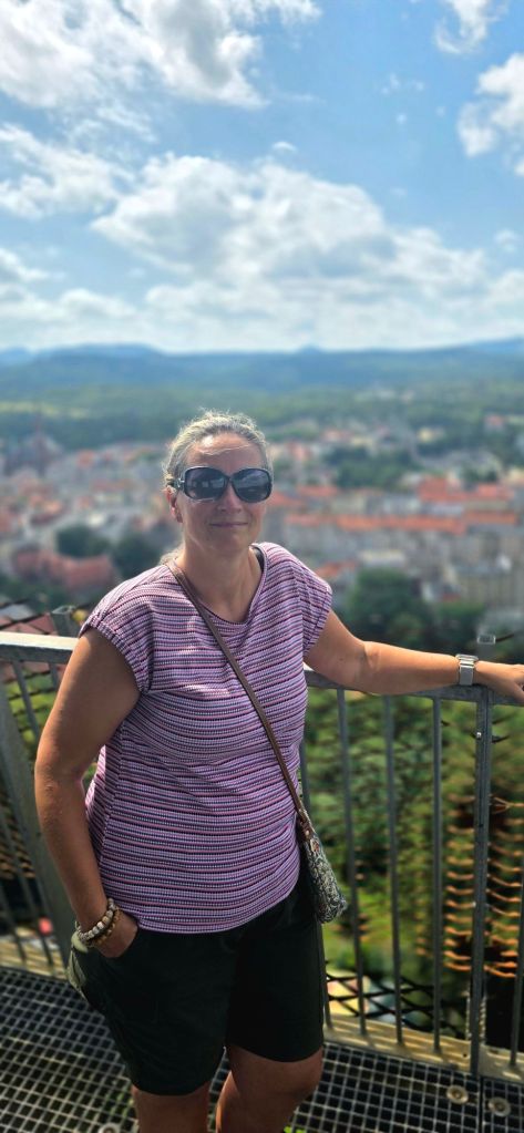 Zdjęcie kobiety w okularach przeciwsłonecznych na tle panoramy starego miasta 